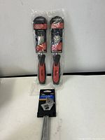 Two new 1-inch wood chisels and an adjustable wrench in original packaging on a flat surface