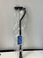 New Carex walking cane still in original plastic wrapping, black color, ergonomic forearm support handle shown vertically against a white background.