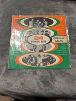 Front cover of 24 Power Hits LP showing colorful design with photos of original stars and title in center.