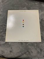 Front cover of Elton John 'Too Low For Zero' vinyl album with white background and centered small graphical icons.