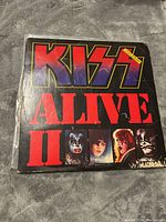 Front cover of Kiss Alive II double LP with visible wear and imagery of band members.