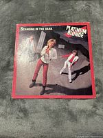 Front cover of the vinyl record album 'Standing In The Dark' by Platinum Blonde showing band members in 1980s styled outfits and album title.