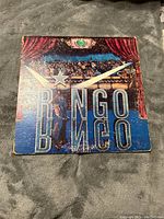 Front cover of Ringo Starr 'Ringo' vinyl album showing illustrated theatrical scene with stage curtains and audience.