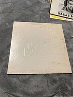 Front of album cover, white with embossed 'Welcome' text showing light wear and spots