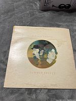 Front cover of Seals and Crofts Summer Breeze vinyl album showing circular portrait illustration and album title with visible wear and water stains.