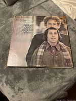 Full view of Simon and Garfunkel Bridge Over Troubled Water vinyl album cover on a gray fabric surface.