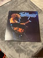 Front cover of Ted Nugent vinyl LP album showing Ted Nugent playing a guitar under dramatic lighting.