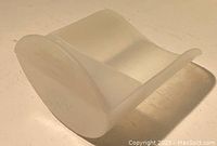 Photo showing the vintage clear plastic scoop from an angle highlighting the smooth curved shape.