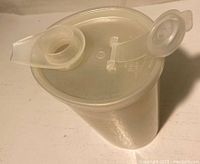 Top view showing the clear lid with hinged spout cover and circular shape of the syrup dispenser.