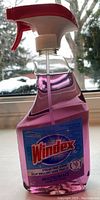 Front view of clear spray bottle with purple liquid and Windex label showing product name, scent, and volume.
