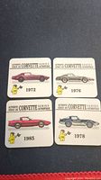 Four square collectible cards showing Corvette designs from 1972, 1976, 1978, and 1985 from the 1991 Hostess series on a dark background.