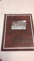 Front cover of the binder labeled "Hockey Collectors Trading Cards" with a maroon leather-like finish.