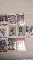 10 rookie NHL hockey cards arranged flat on light surface showing front faces of cards and player images.