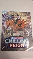 Closed fold-out poster showing front cover with a Pokemon character and Sword & Shield Chilling Reign logo