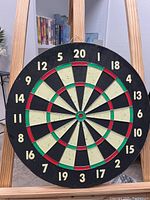 Front view of circular professional dartboard with standard numbering and segmented scoring areas.