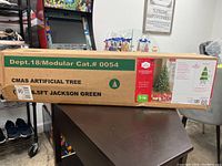 Box labeling showing specifications: CMAS Artificial Tree, 6.5ft Jackson Green model, modular catalog number 0054