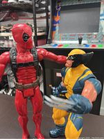 Overview of Deadpool and Wolverine figurines side by side showing size and details