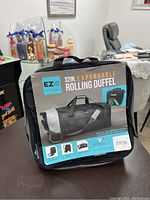 Front label of the rolling duffel bag showing brand EZ UNZ and specifications including 32 inch expandable size and material details.