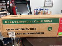 Side view of box labeled 'CMAS Artificial Tree 6.5ft Jackson Green' with modular catalog number 0054.