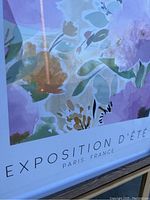 Close-up of floral print poster text 'EXPOSITION D'ÉTÉ PARIS, FRANCE' with visible soft pastel floral design