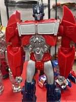 Red, blue, and silver Optimus Prime Transformer figure with detailed armor and Autobot insignias visible on shoulders.