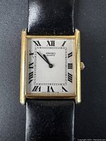 Front view of the vintage rectangular Seiko quartz watch showing dial, Roman numerals, and black leather strap.