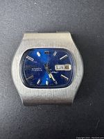 Front view of vintage Seiko men's automatic wristwatch with blue dial, silver hour markers, and day-date window at 3 o'clock. The watch case is stainless steel with a brushed finish.