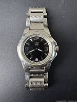 Front view showing the watch face, metal case, and band with visible wear and brand name ESQ SWISS on dial.