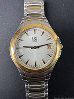 Front view close-up of the ESQ Swiss watch face showing white dial with gold-tone markers and date window.