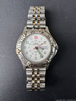 Front view showing watch dial, hands, brand logo and day-date display