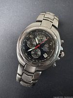 Front angled close-up of the Timex chronograph watch showing black dial, three subdials, date window, and stainless steel bracelet.