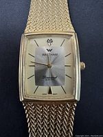 Front view of rectangular gold-tone Waltham men's quartz watch with diamond accent at 12 o'clock and gold mesh band.