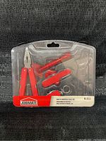 Front view of sealed Jobmate multi-purpose tool set in plastic packaging with 6 pieces visible including multi-tool pliers and folding knife.