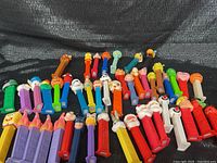 Front angle showing 45 PEZ dispensers in various colors and character heads including Halloween, Santa, pumpkin, playful characters
