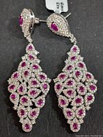 Front view of pair of silver earrings, showing pink pear-shaped stones and clear cubic zirconia detailing.