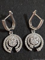 Top-down view showing shape, fastening, and CZ stones on silver earrings