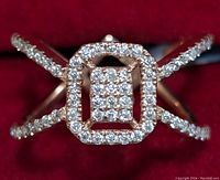 Detailed close-up of silver ring with square cluster of moissanite stones and split band adorned with moissanite