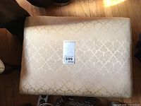 Top view of the rectangular gold brocade footstool showing the damask pattern and fabric sheen.