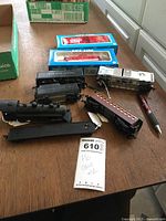 HO scale model train engine and cars displayed on a wooden table along with pen and lot tag