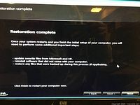 Monitor screen showing system restoration completion message after reset of Windows 7 on the HP tower PC.