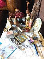 Full lot showing horse and giraffe figurines, carved man, soft chickens, vase, plate, spoons and cards.