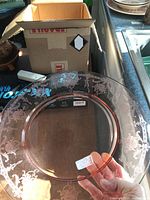 Clear glass footed platter showing floral etching around rim and some surface scratches