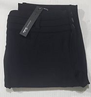 Folded black tapered pants with three-button closure and attached tag showing the brand 'Sloane & Sadies'. Pants are size 14 and new with tags.