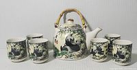 Full view of the tea set showing teapot and six cups with panda illustrations and bamboo handle on teapot