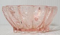 Side view showing embossed floral pattern on pink Depression glass candy dish