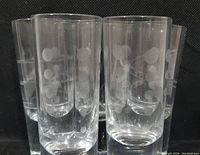 Five clear etched shooter glasses with bubble-like designs and weighted bases.