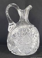 Front and side view of vintage hand cut ABP crystal whiskey pitcher showing clear crystal and starburst pattern.