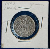 Obverse side of 1903 German 1 Mark silver coin showing imperial eagle design, encased in a white coin holder with handwriting.
