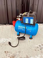 Front view of the blue Mastercraft 2 gallon air compressor showing power cord and top handle.