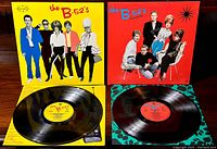 Two B-52's vinyl LP records with covers and records displayed: self-titled album with yellow cover and Wild Planet album with red cover.